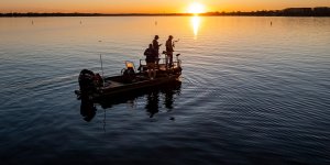 A group of men fishing on a boat in the lake
