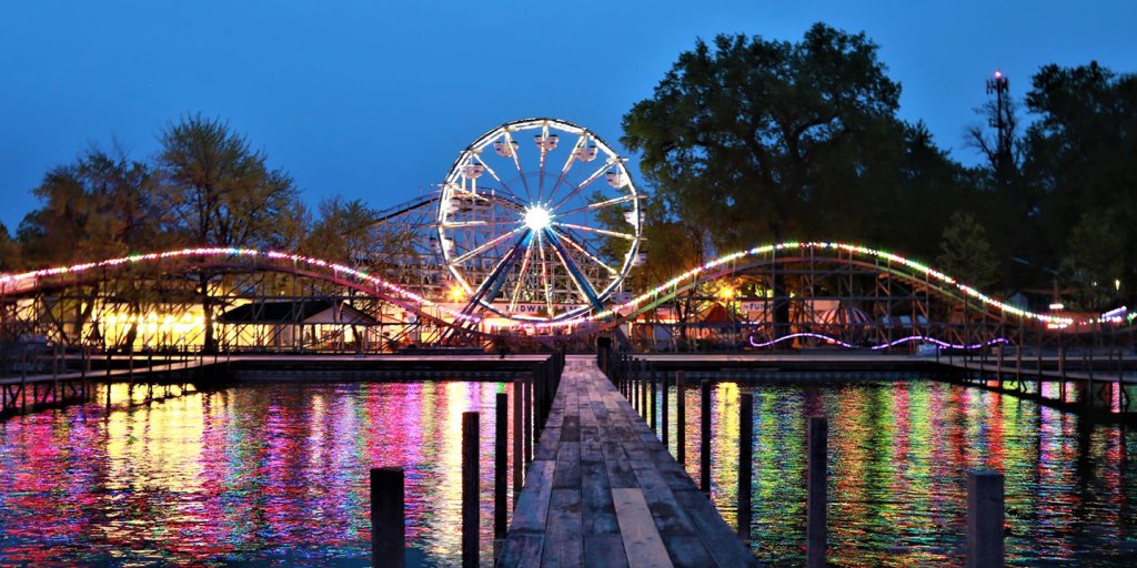 A ferris wheel on a dock lit up at night.