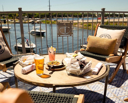 City of Orleans 3 A table with food on it and a drink on the table outside by a lake